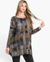 A woman modeling a long-sleeve, boat-neck tunic top with a textured patchwork plaid pattern in muted shades of gray, brown, olive green, and beige, paired with black pants against a plain white background.