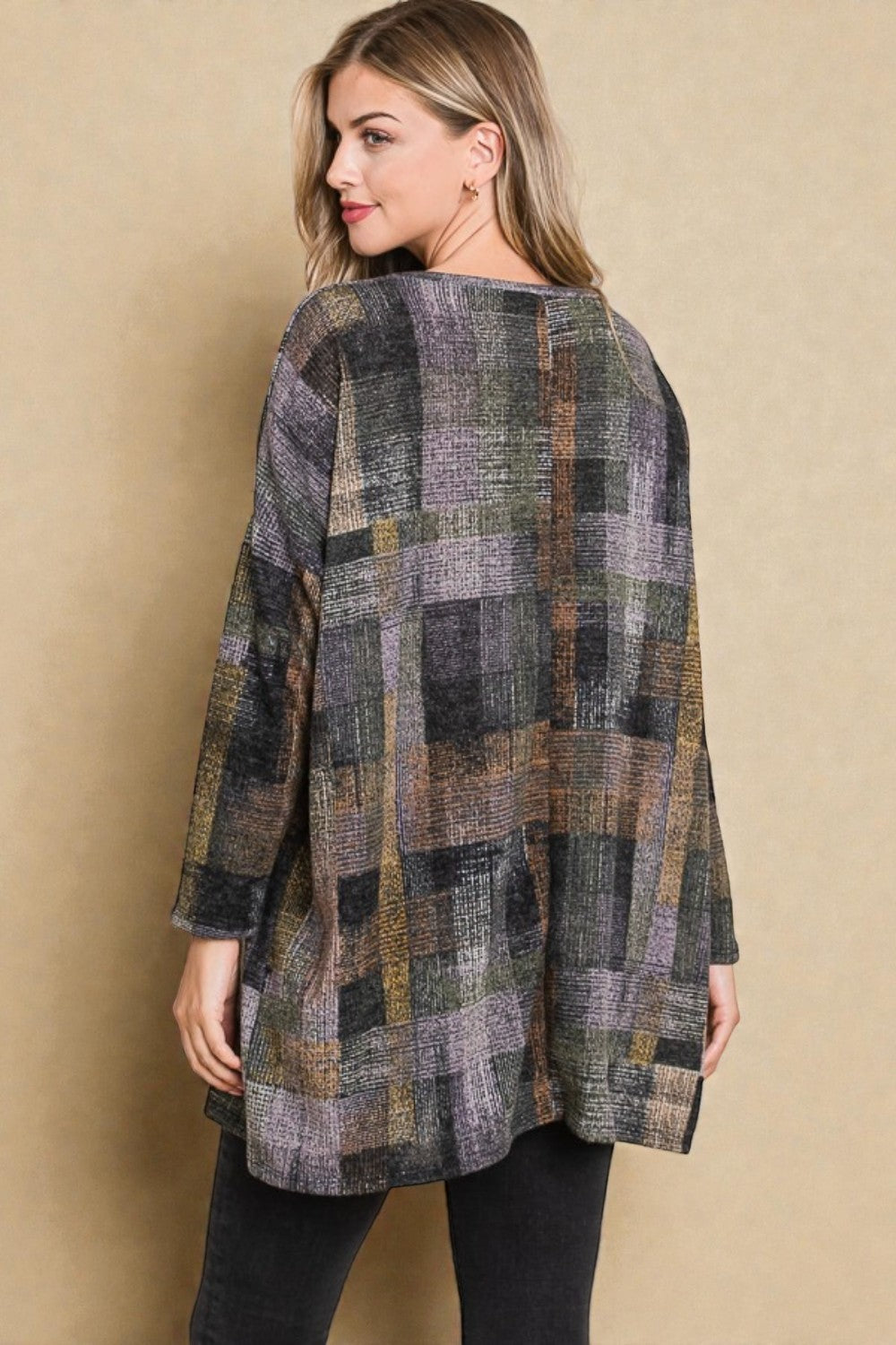 Woman wearing a plaid jacket against a beige background