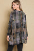 Woman wearing a plaid jacket against a beige background