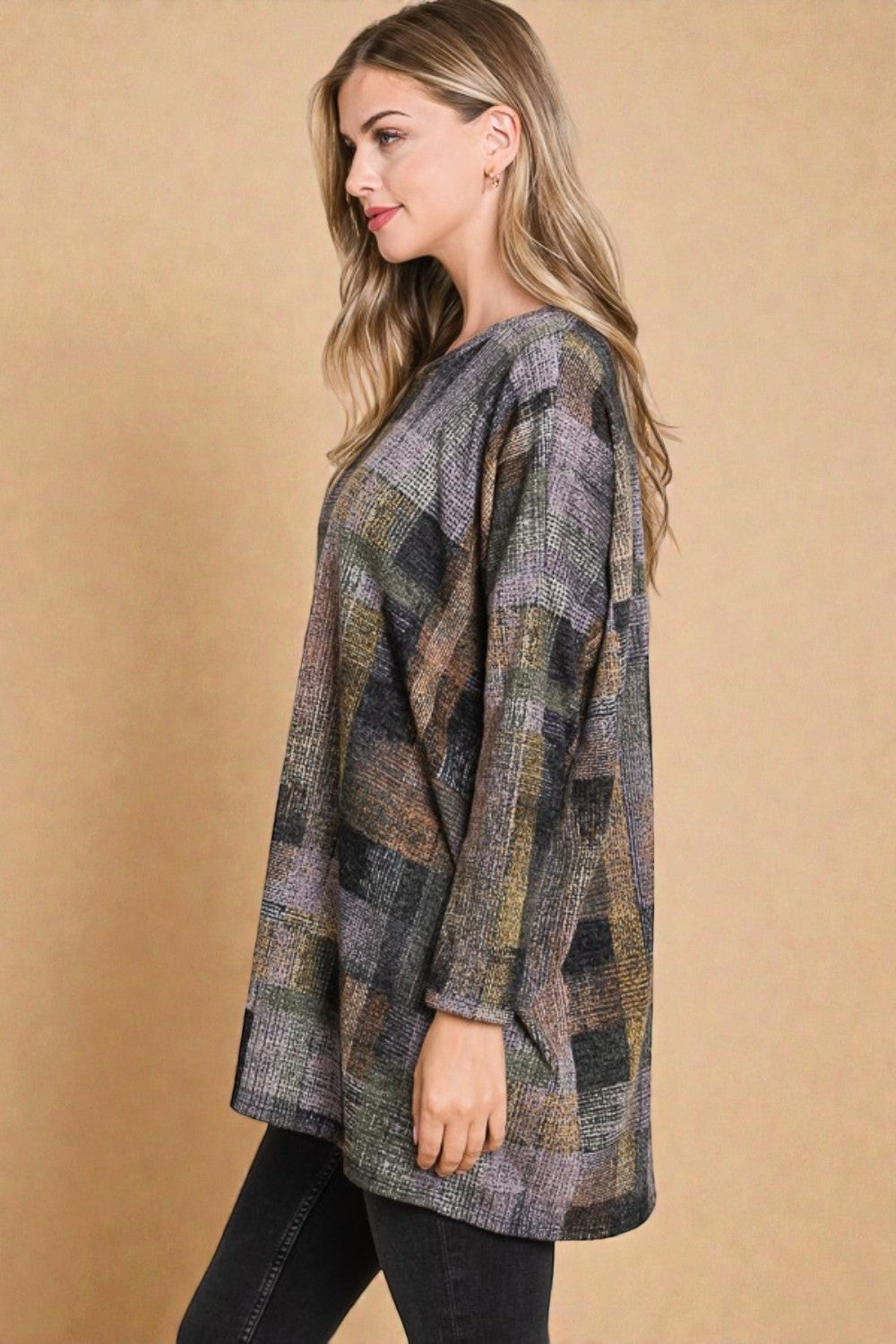 Woman wearing a patterned sweater against a beige background