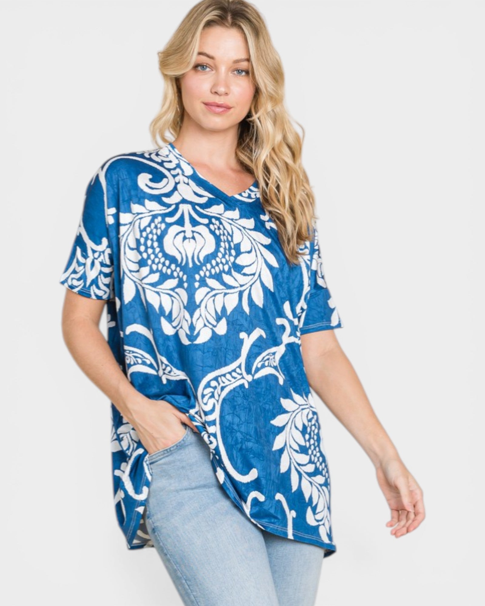 Woman wearing a blue and white patterned top on a plain background