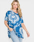 Woman wearing a blue and white patterned top on a plain background