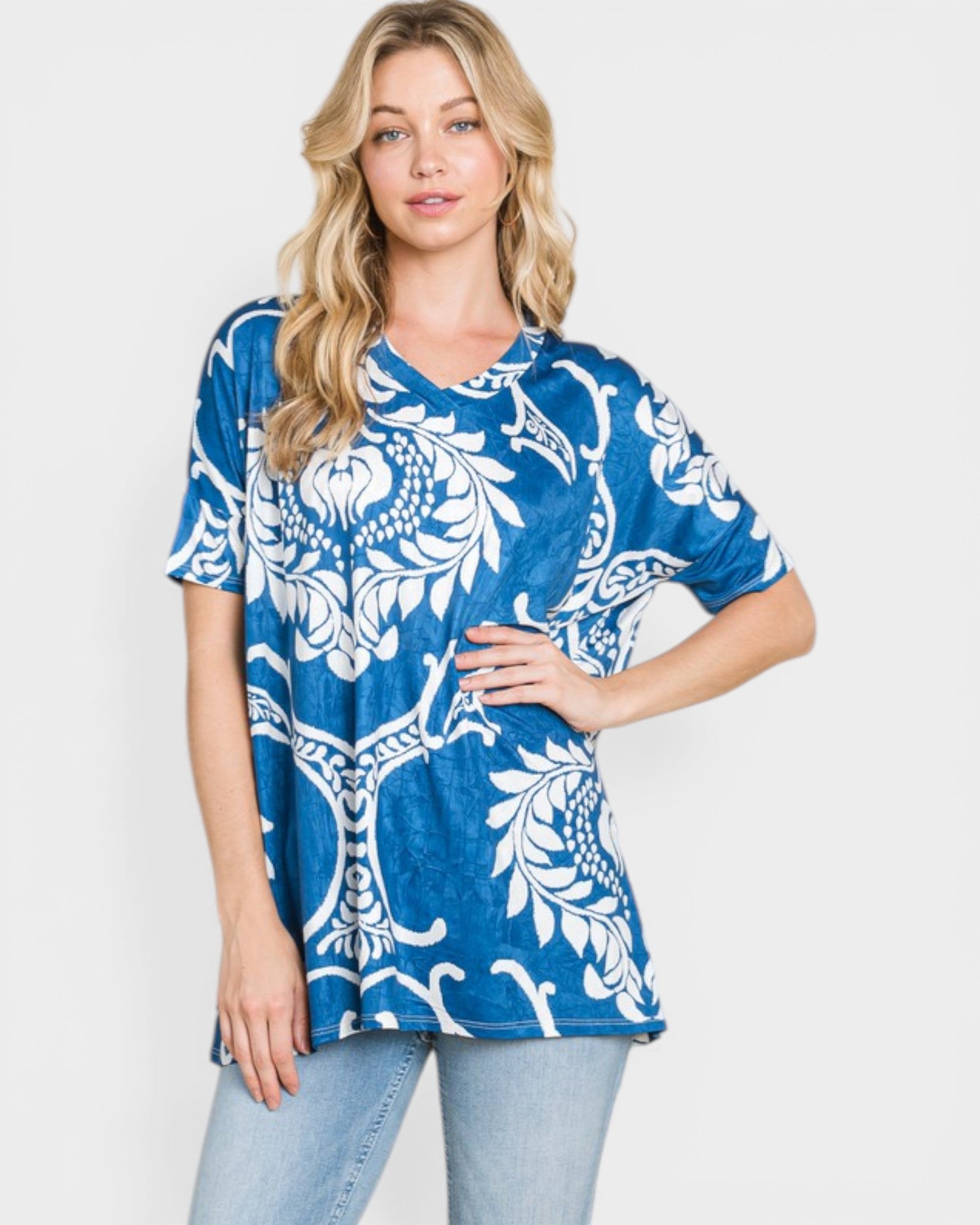 Woman wearing a blue and white patterned top on a plain background