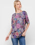 Woman wearing a colorful patterned top on a white background