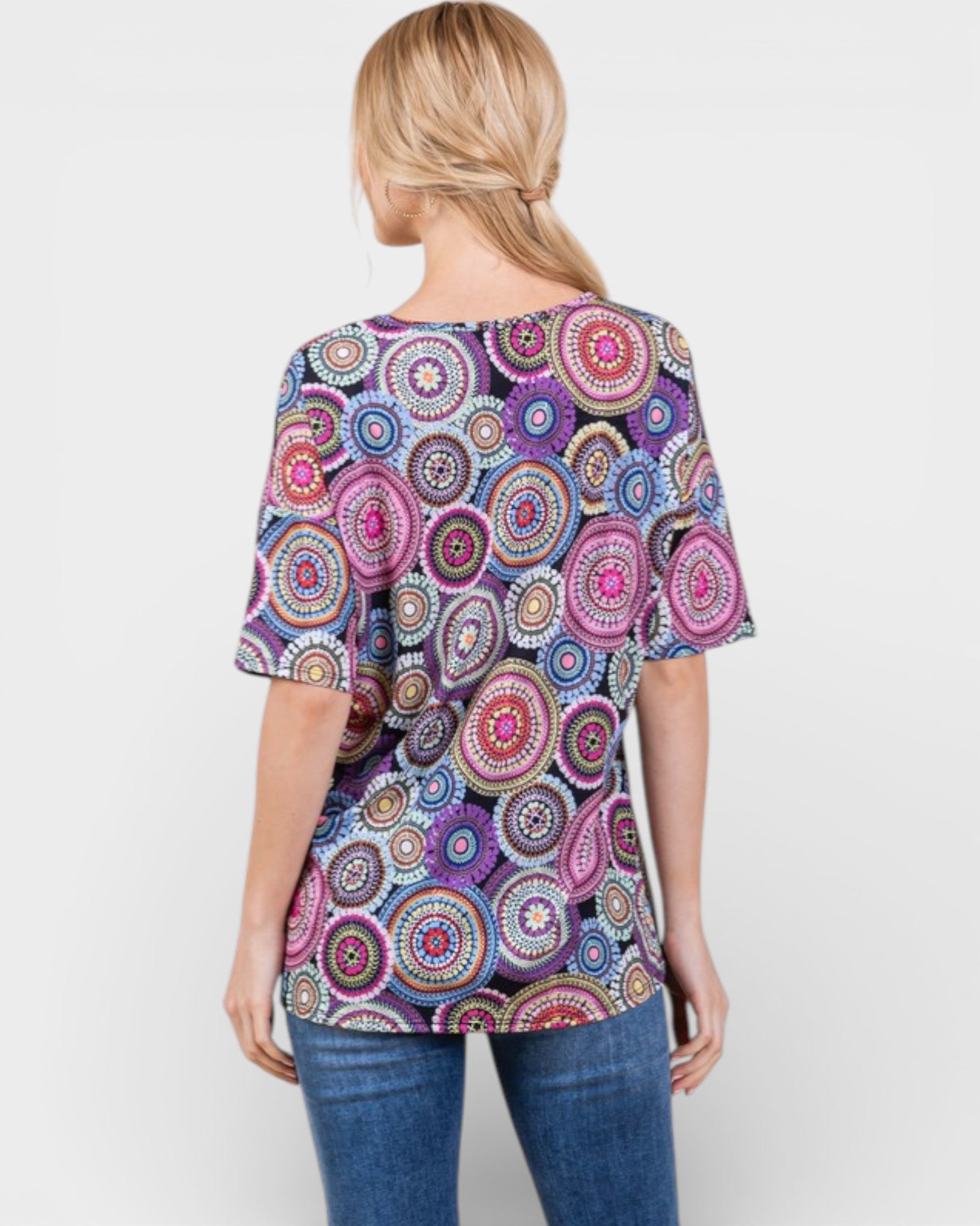 Woman wearing a colorful patterned top on a white background