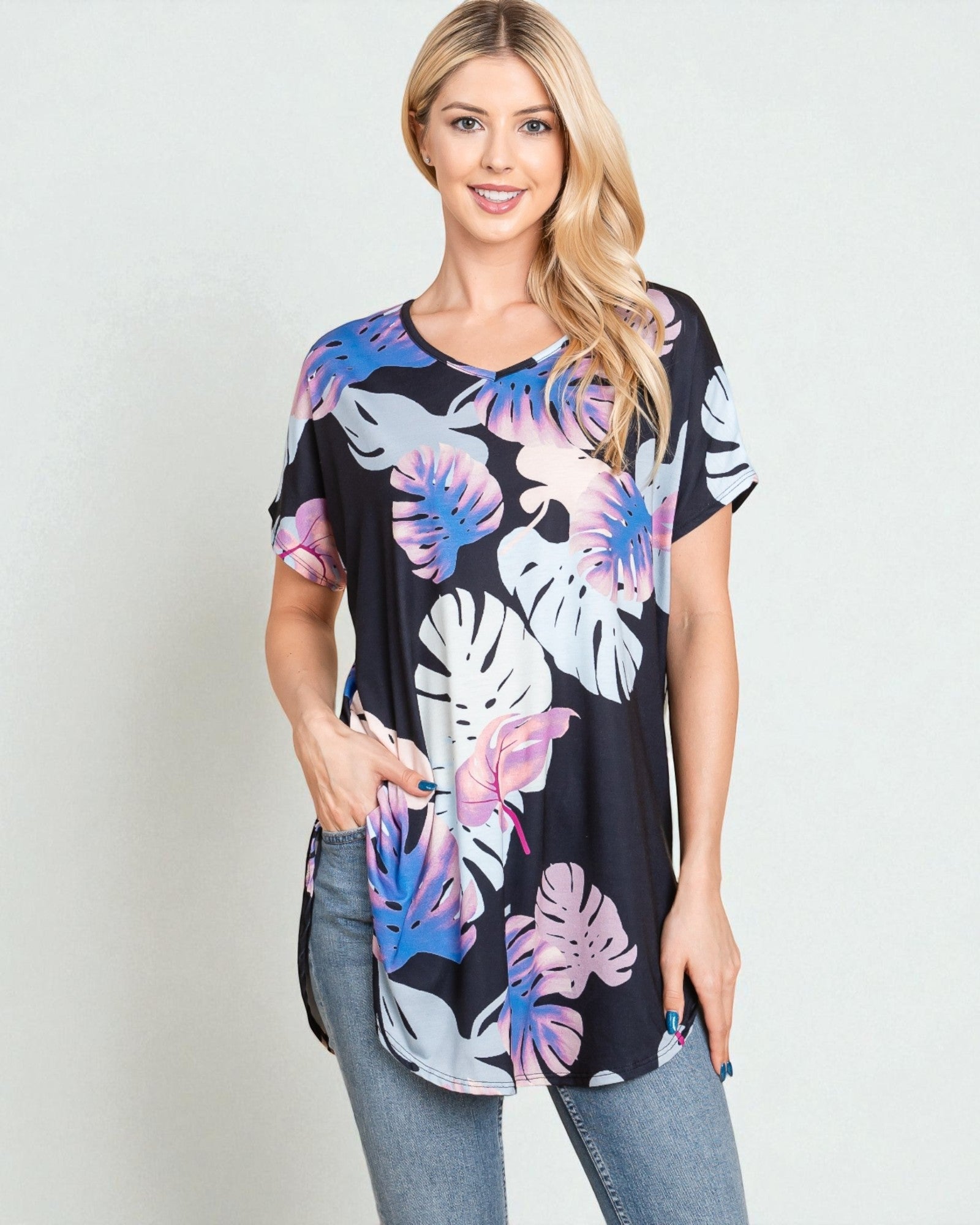 Woman wearing a black t-shirt with colorful floral pattern on a plain background