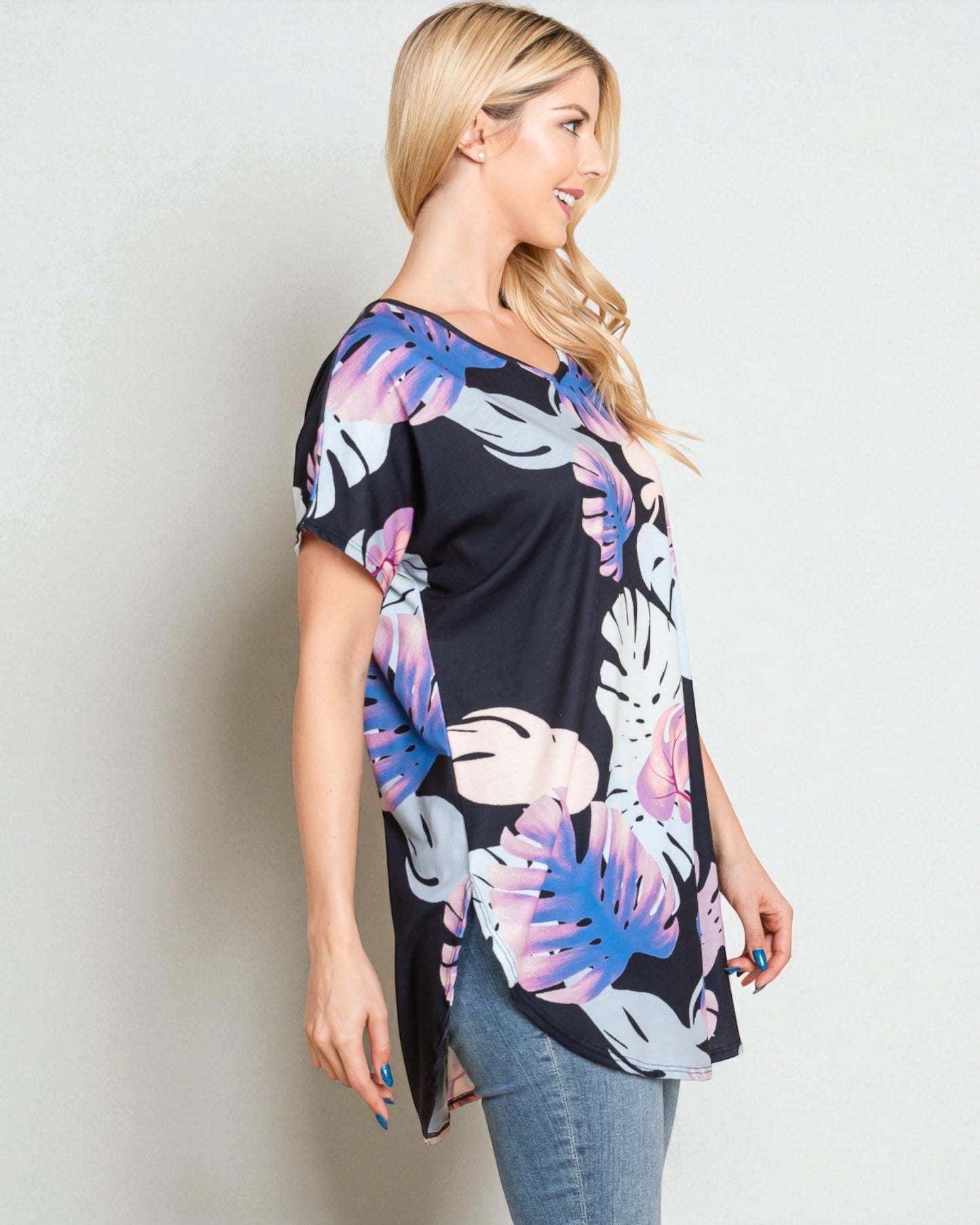 Woman wearing a black floral kimono-style top against a plain background