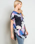 Woman wearing a black floral kimono-style top against a plain background