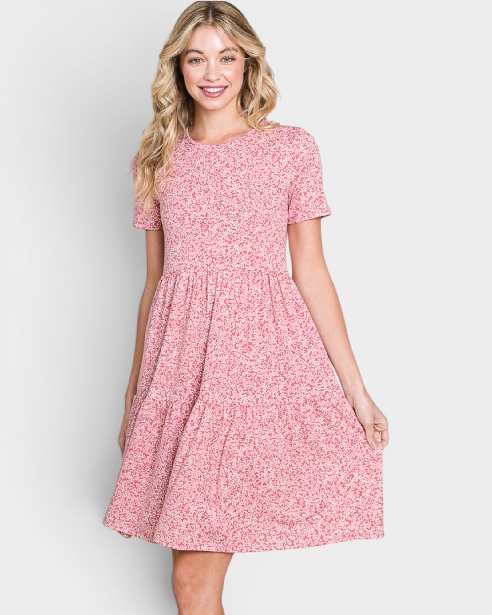Woman wearing a pink floral dress on a white background