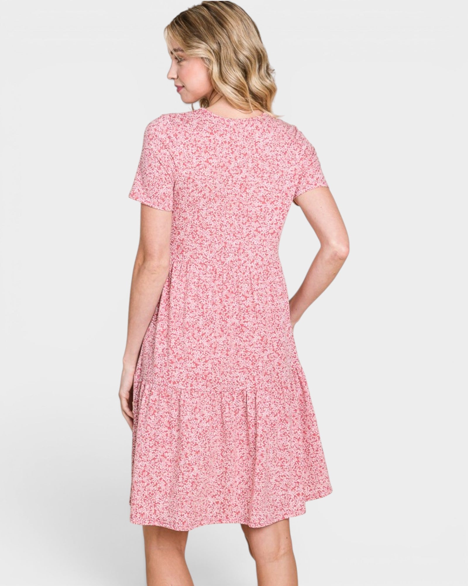 Woman wearing a pink floral dress on a white background