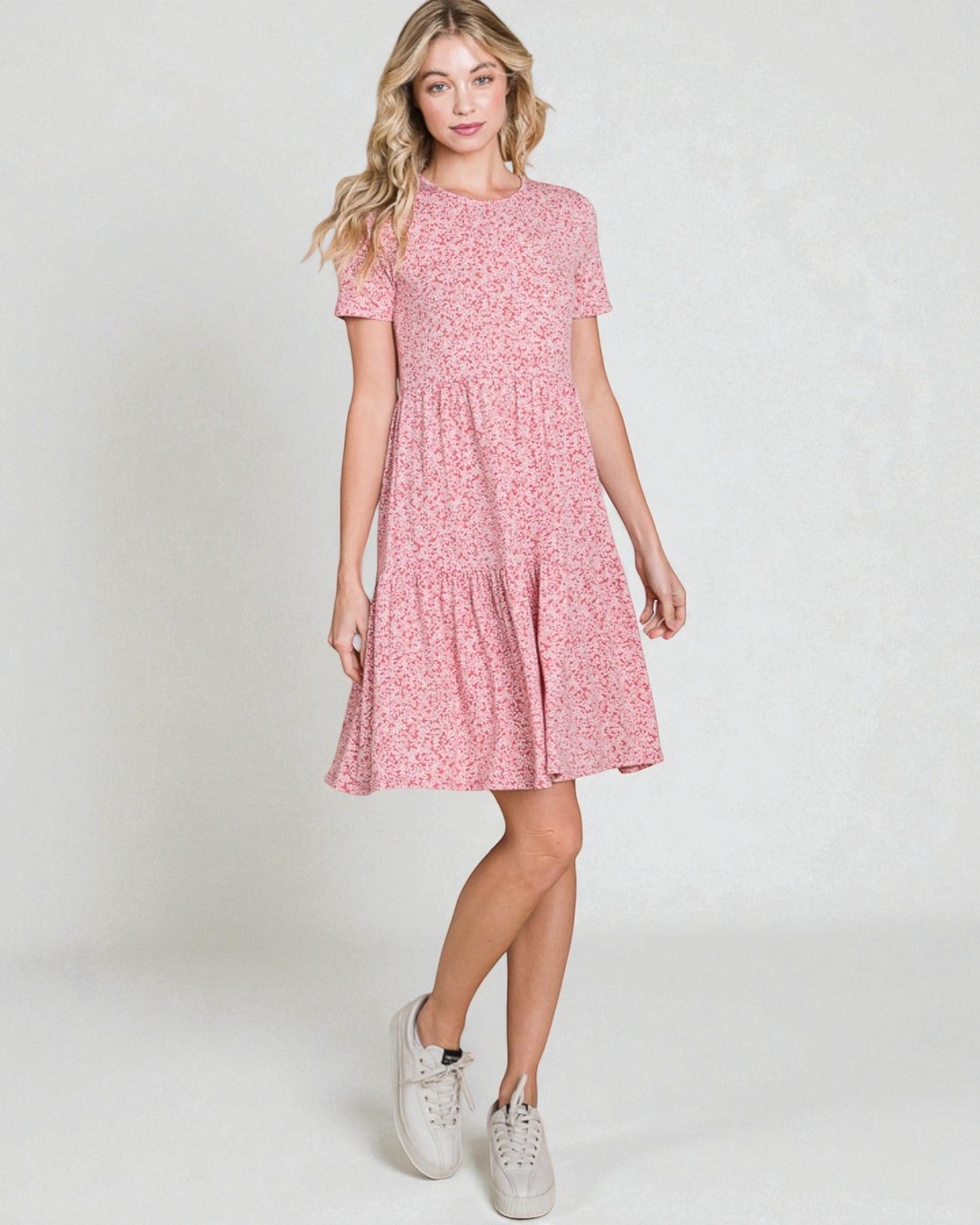 Woman wearing a pink floral dress on a white background