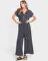 Woman wearing a gray jumpsuit with button details on a white background