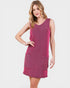 Woman wearing a pink sleeveless dress with pockets on a white background