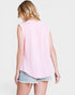 Person wearing a pink sleeveless top and denim shorts on a light background