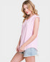 Woman wearing a pink sleeveless top and denim shorts on a white background