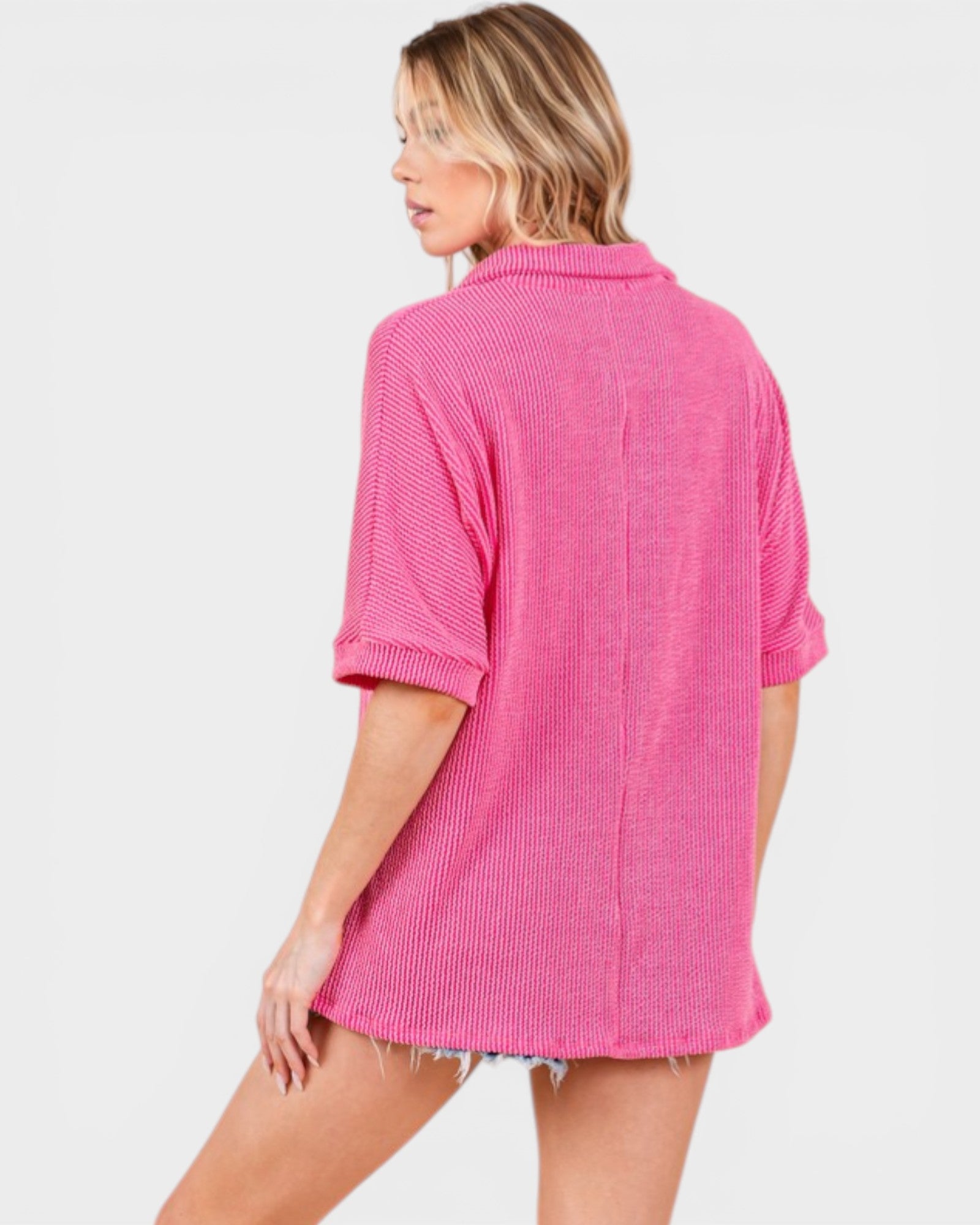 Woman wearing a pink ribbed sweater on a white background