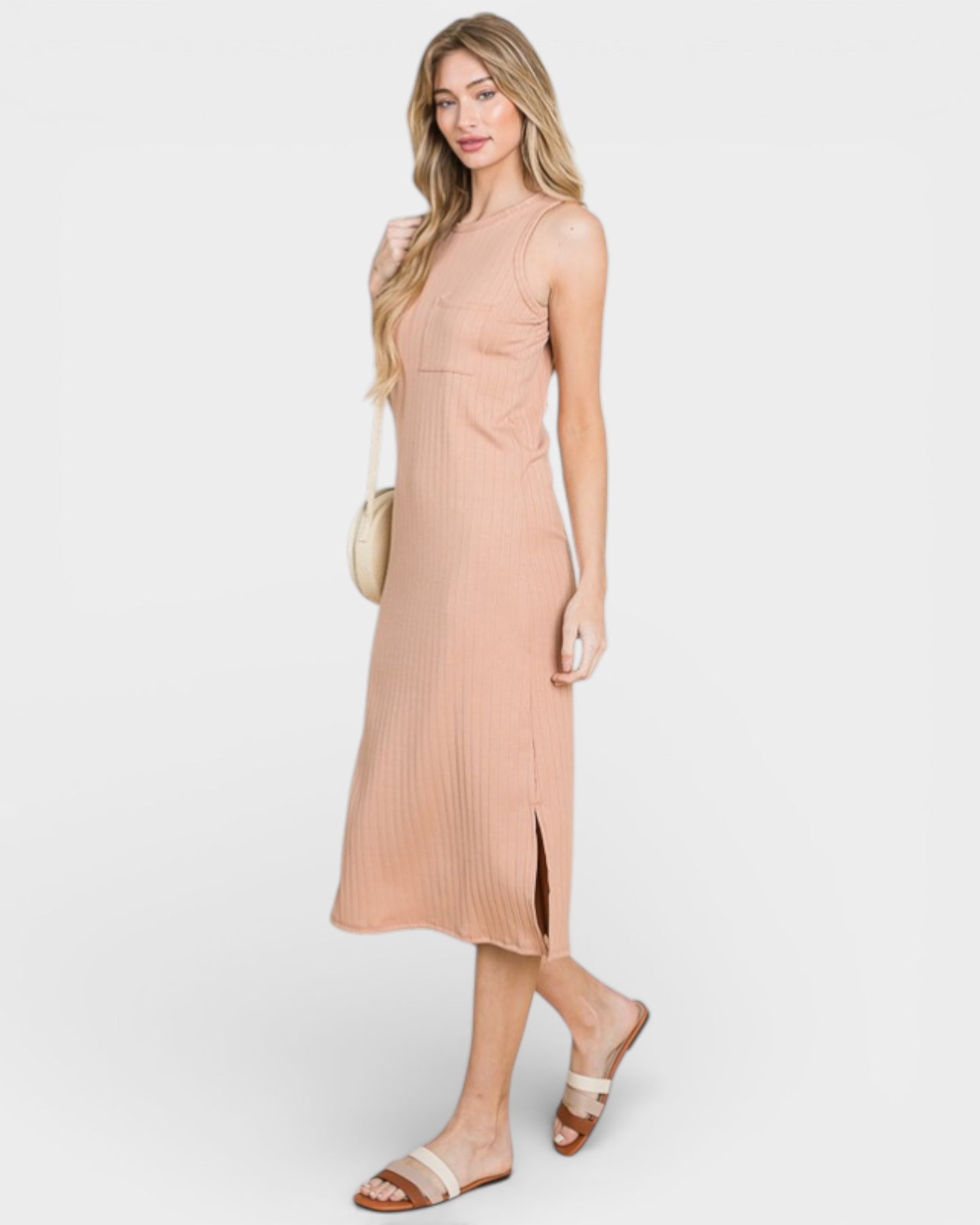 Woman wearing a light pink ribbed dress on a white background