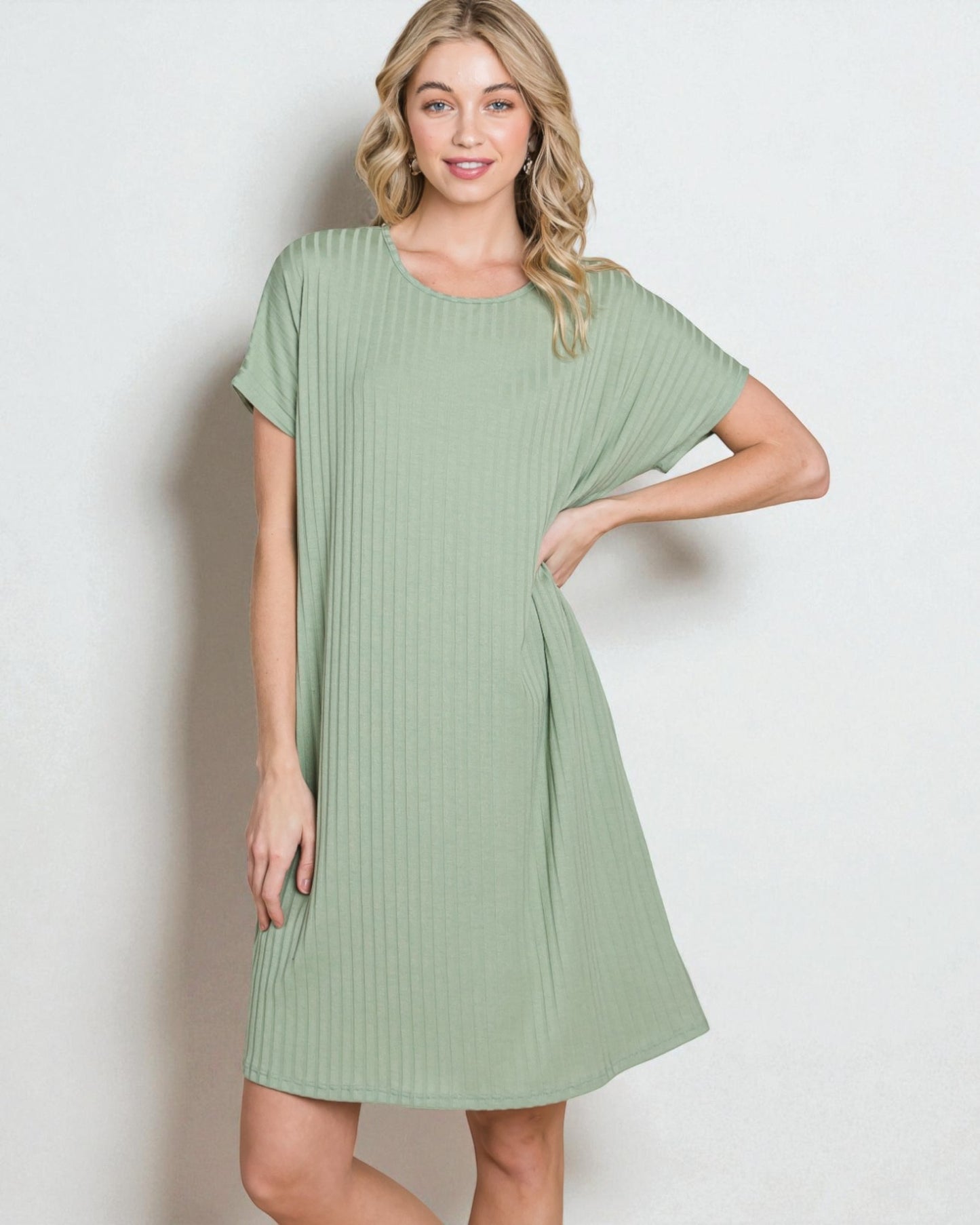 Woman wearing a green dress against a plain background