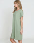 Woman wearing a green ribbed dress against a white background