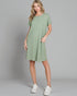 Woman wearing a green dress with white sneakers on a gray background