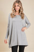 Woman wearing a gray long-sleeve tunic on a beige background