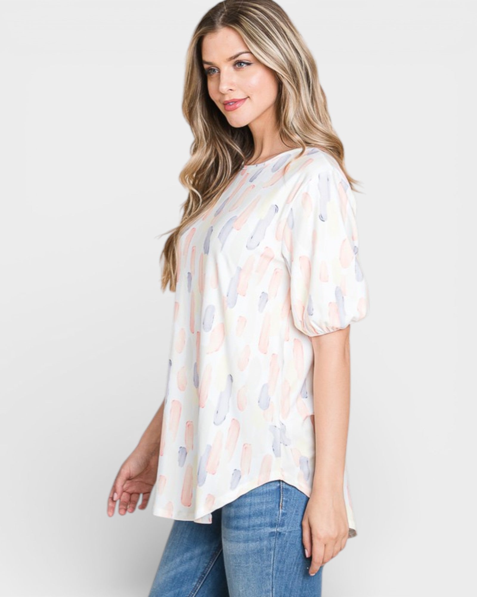 Woman wearing a patterned blouse and jeans on a white background