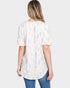 Woman wearing a patterned blouse with a plain background