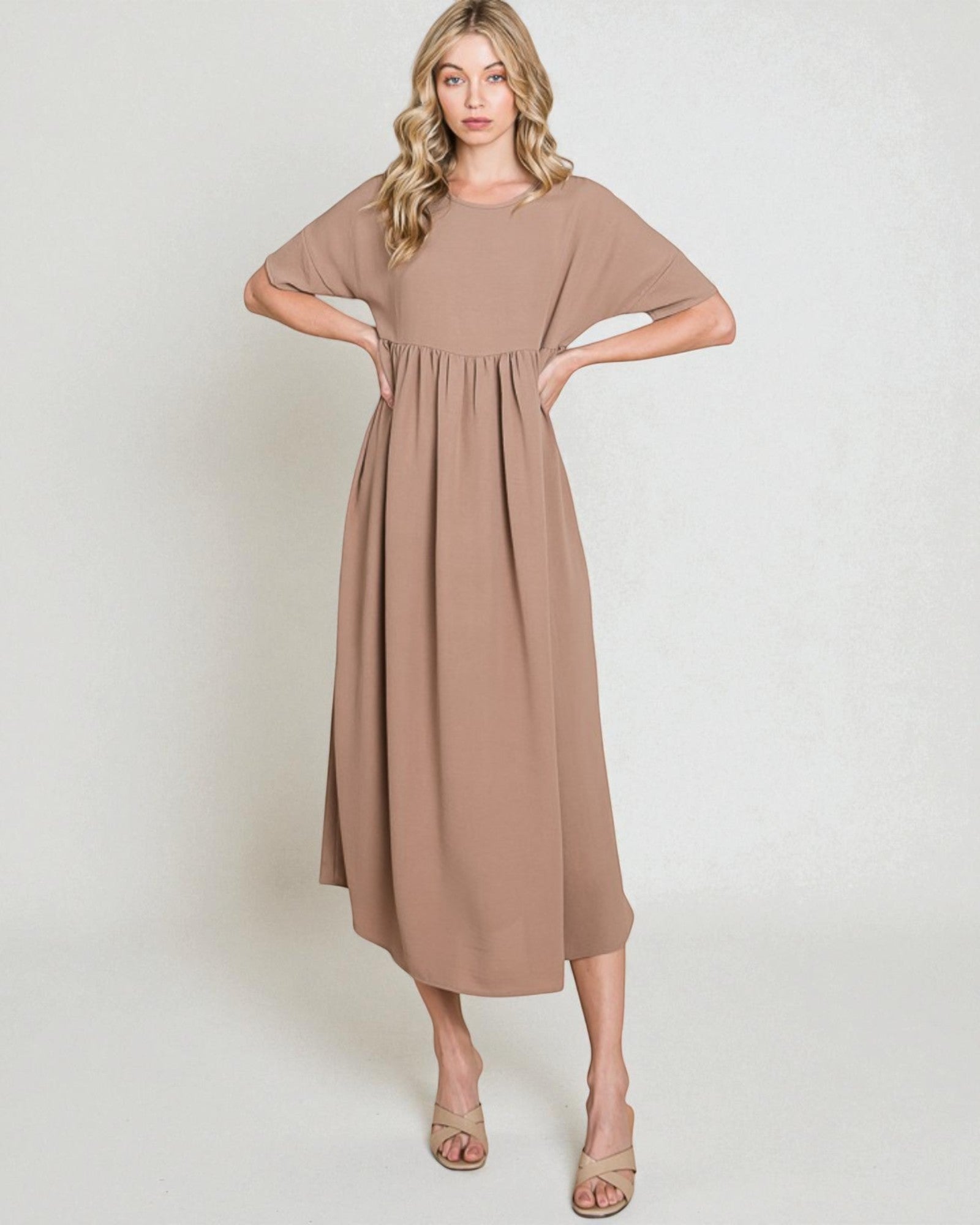 Woman wearing a brown dress against a white background