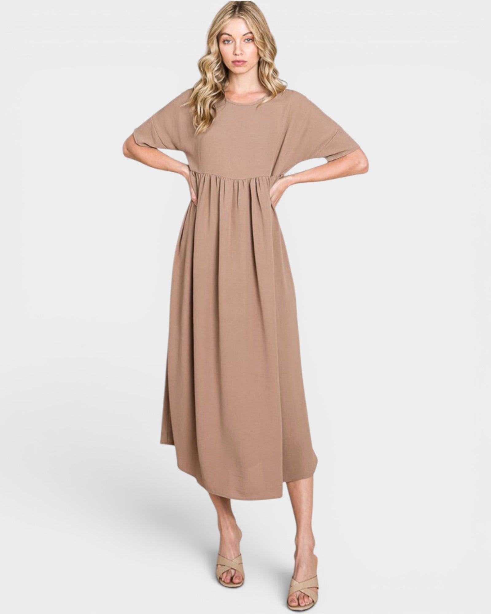 Woman wearing a beige dress on a white background