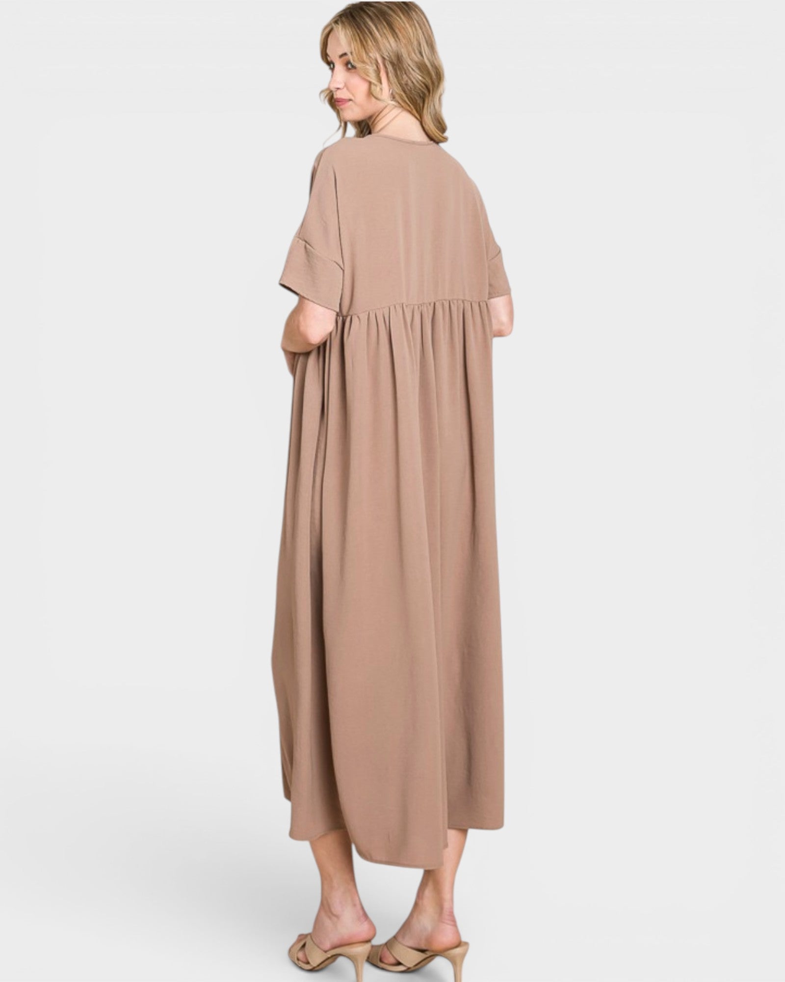 Woman wearing a beige dress on a white background