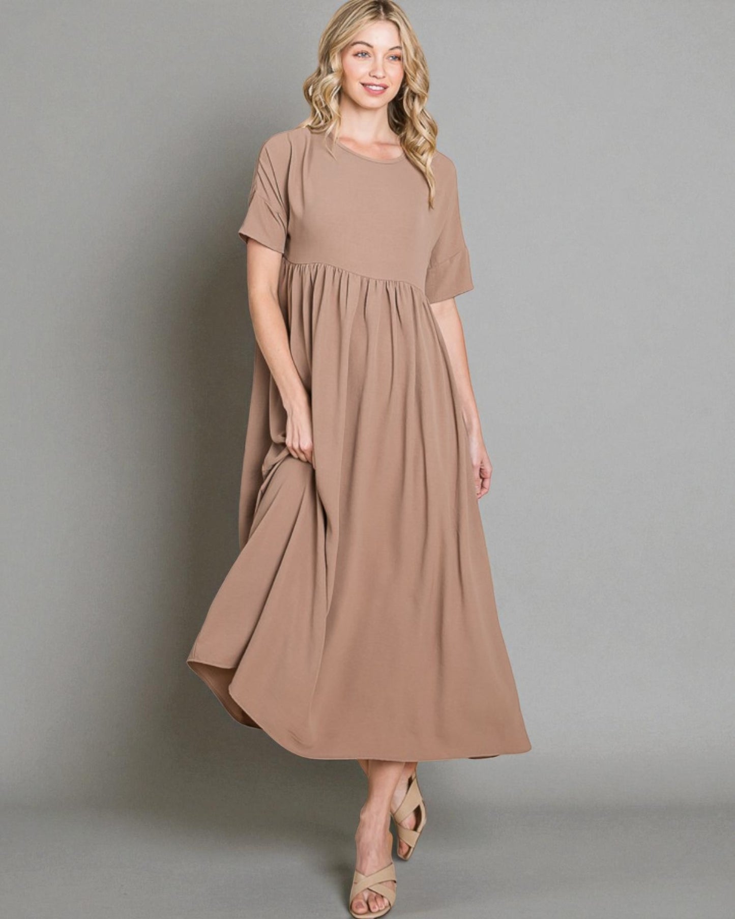 Woman wearing a brown dress against a gray background