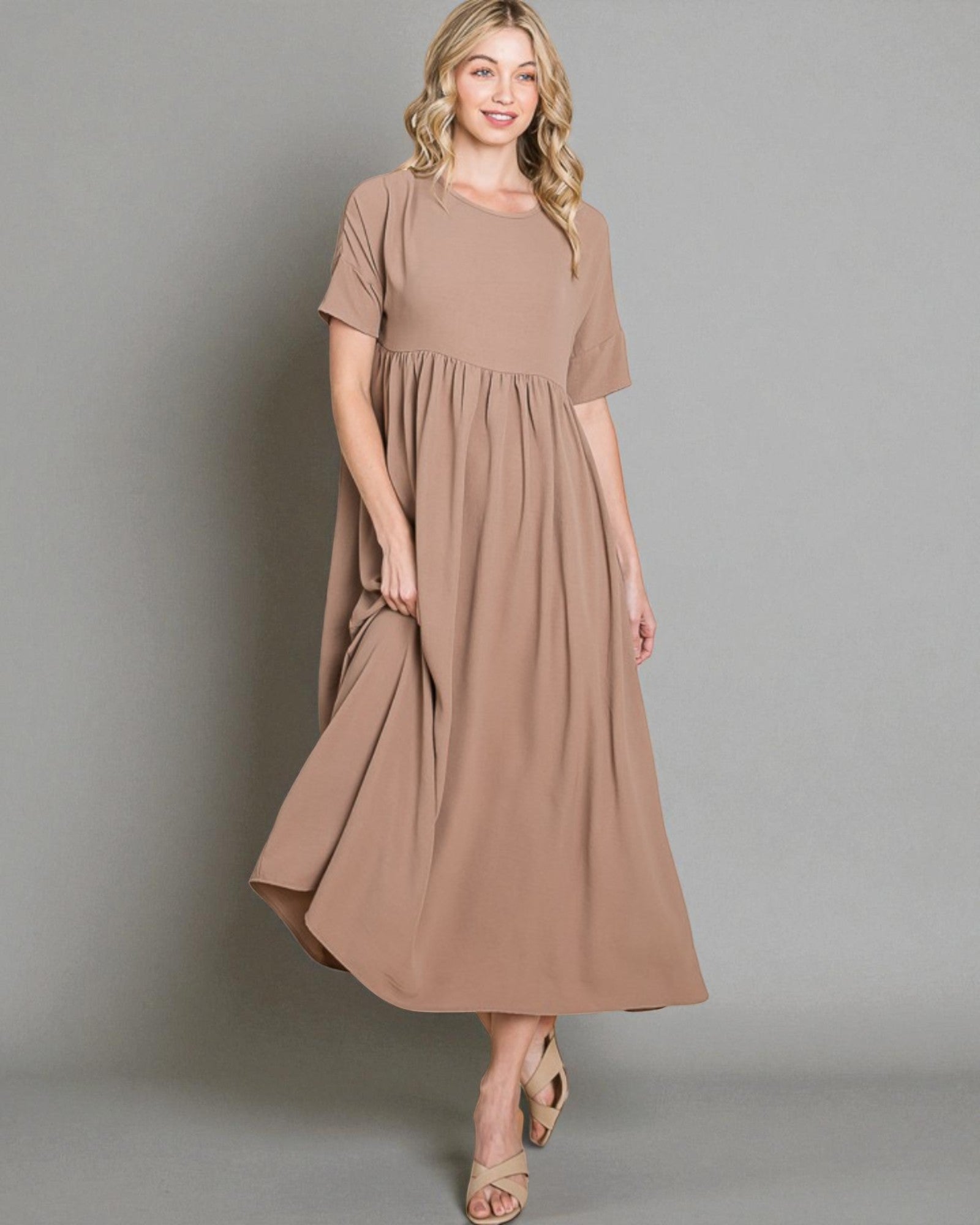 Woman wearing a brown dress against a gray background