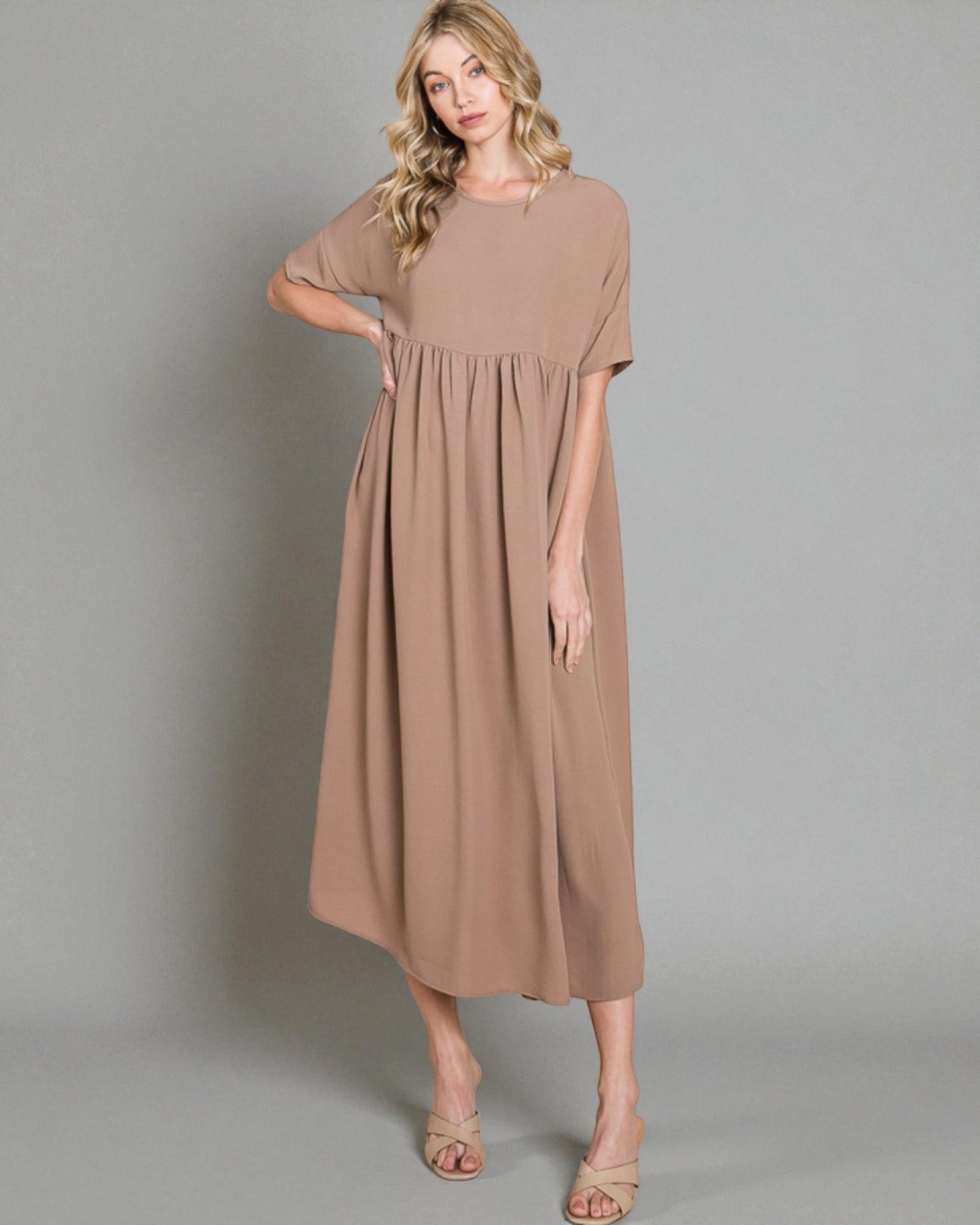 Woman wearing a brown dress against a gray background