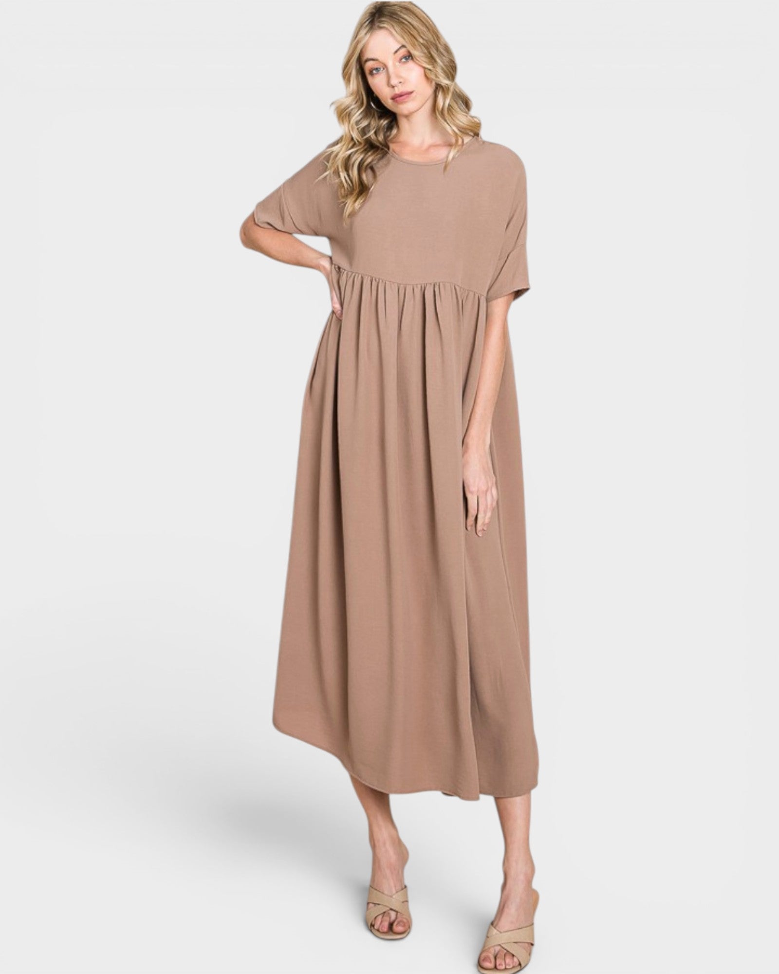 Woman wearing a beige dress on a white background