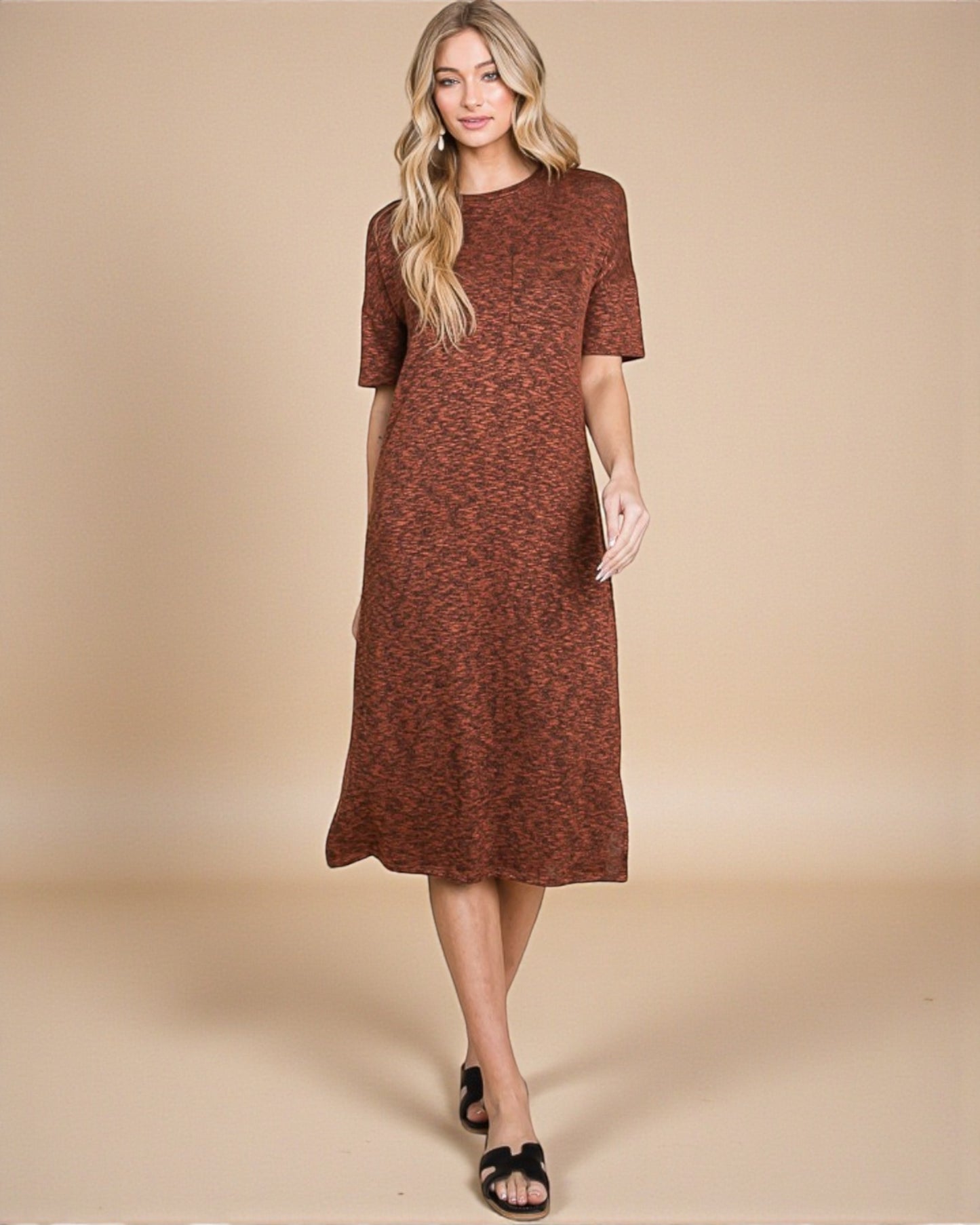 Woman wearing a brown patterned dress against a beige background