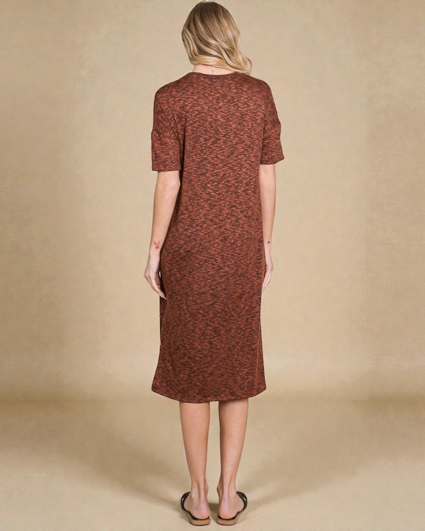 Woman wearing a brown dress against a beige background