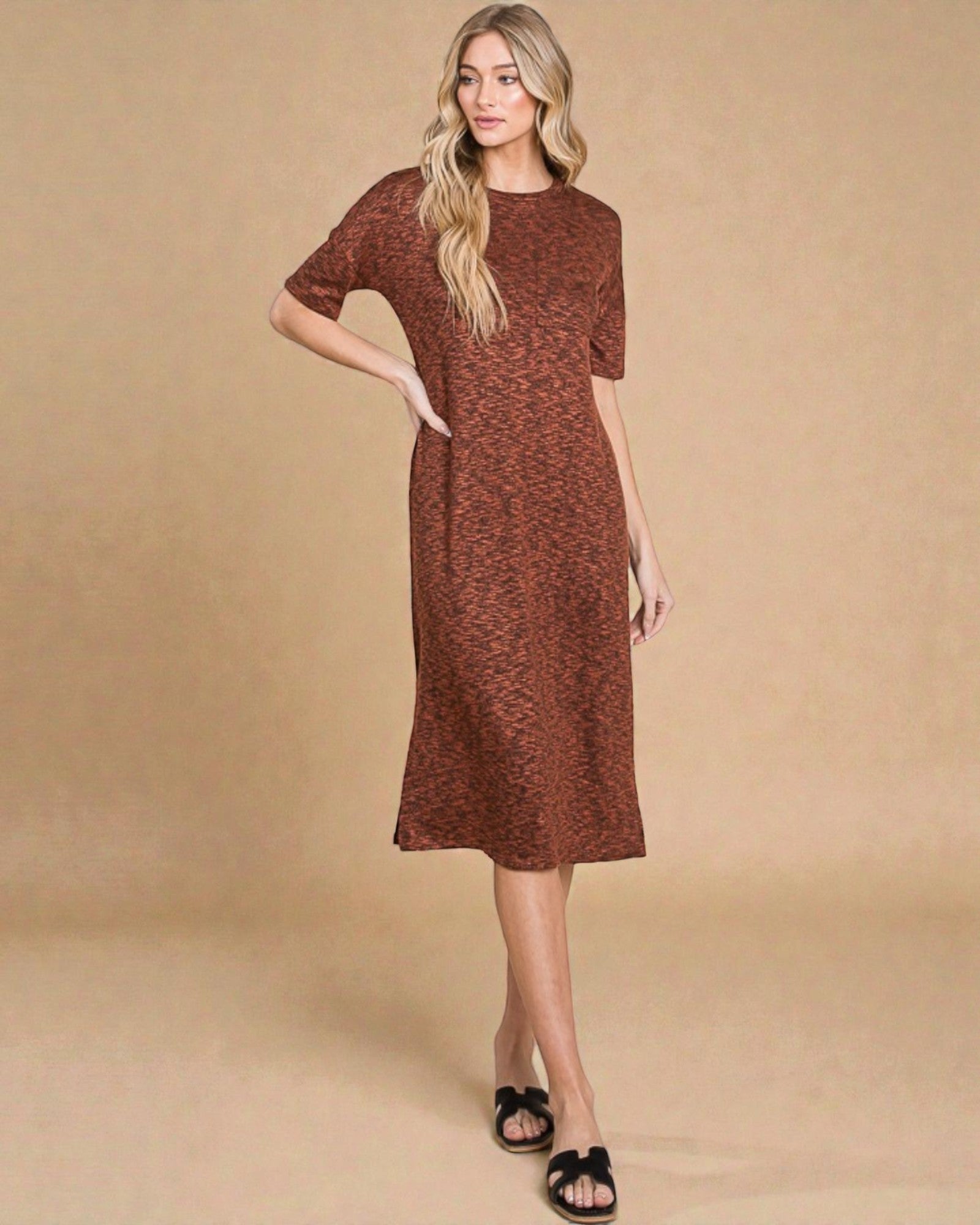 Woman wearing a brown patterned dress against a beige background