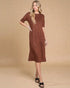 Woman wearing a brown patterned dress against a beige background