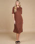 Woman wearing a brown dress against a beige background