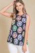 Woman wearing a sleeveless top with colorful smiley face pattern on a beige background