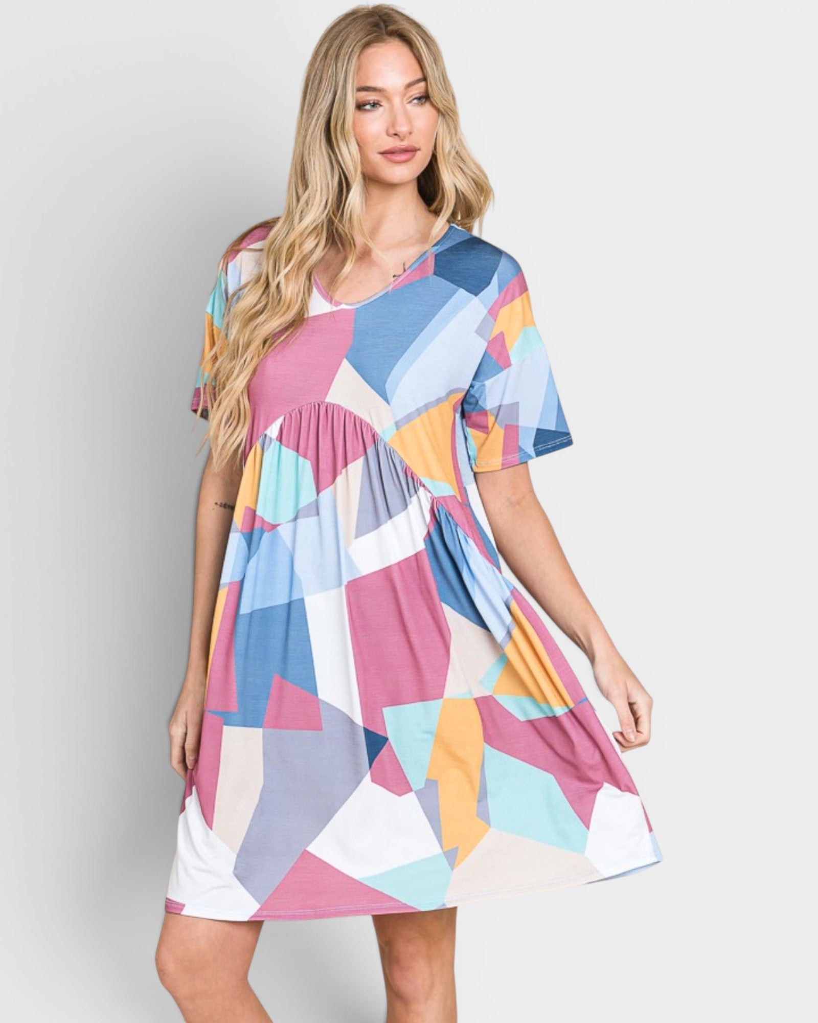 Woman wearing a colorful geometric patterned dress on a plain background