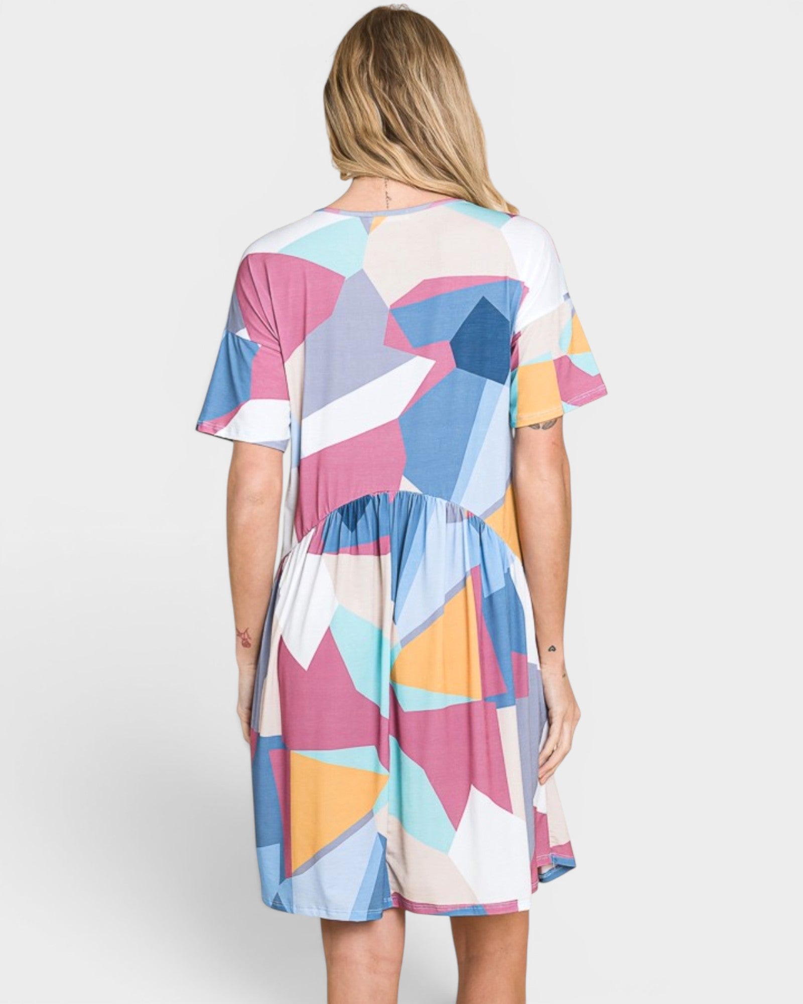 Woman wearing a colorful geometric patterned dress on a white background