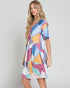 Woman wearing a colorful patterned dress on a plain background