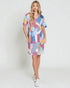 Woman wearing a colorful patterned dress on a white background