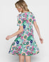 Woman wearing a colorful floral dress on a white background