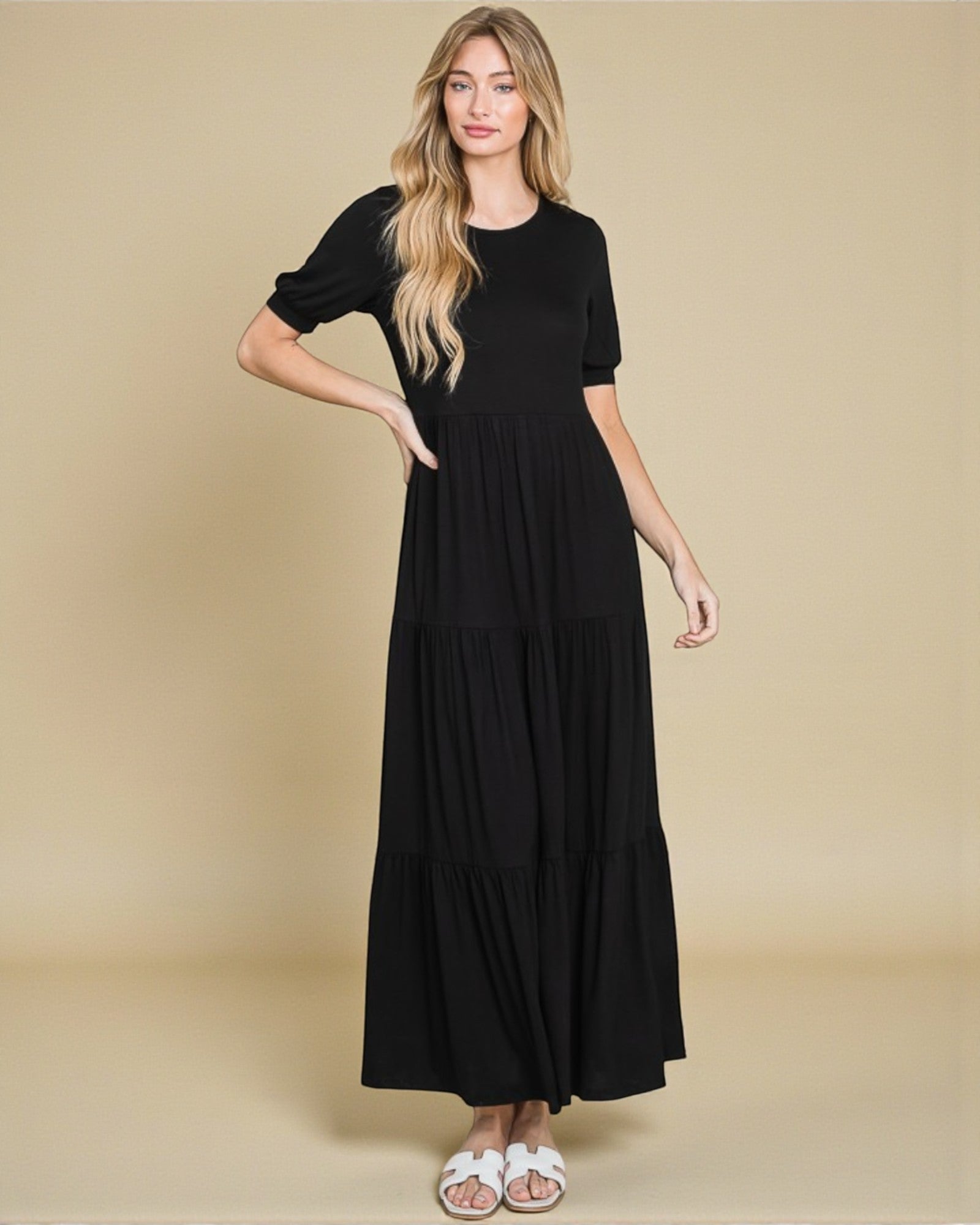 Woman wearing a black dress against a beige background