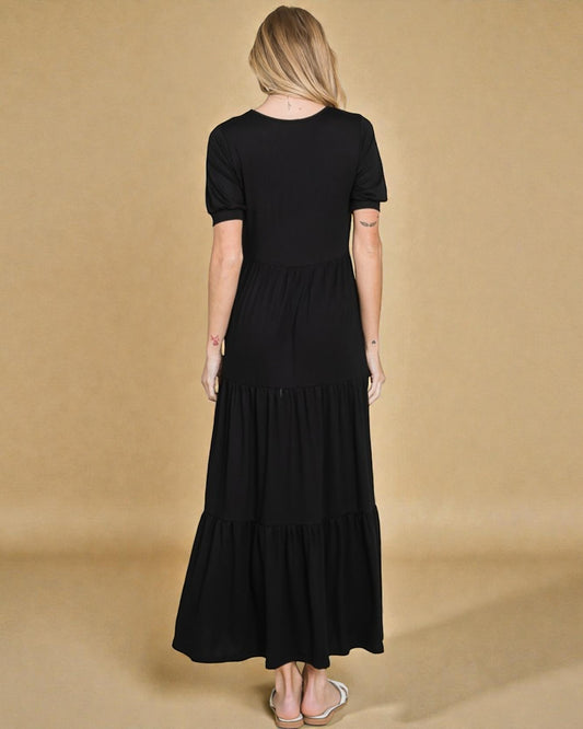 Woman wearing a black dress against a beige background