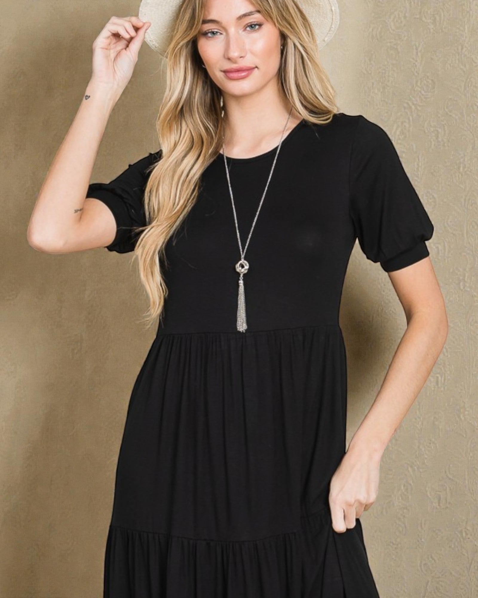 Woman wearing a black dress with a neutral background