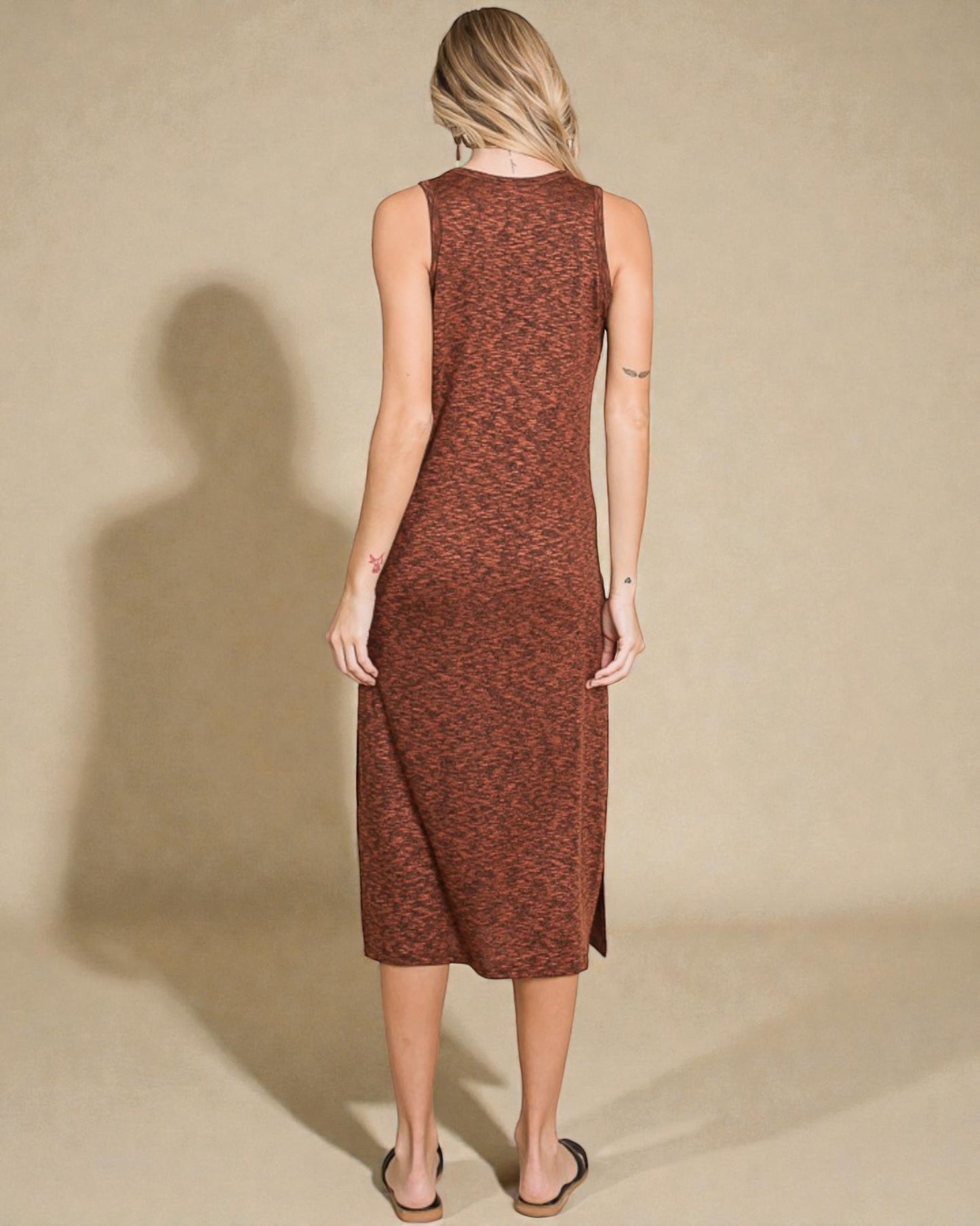 Woman wearing a brown sleeveless dress against a beige background