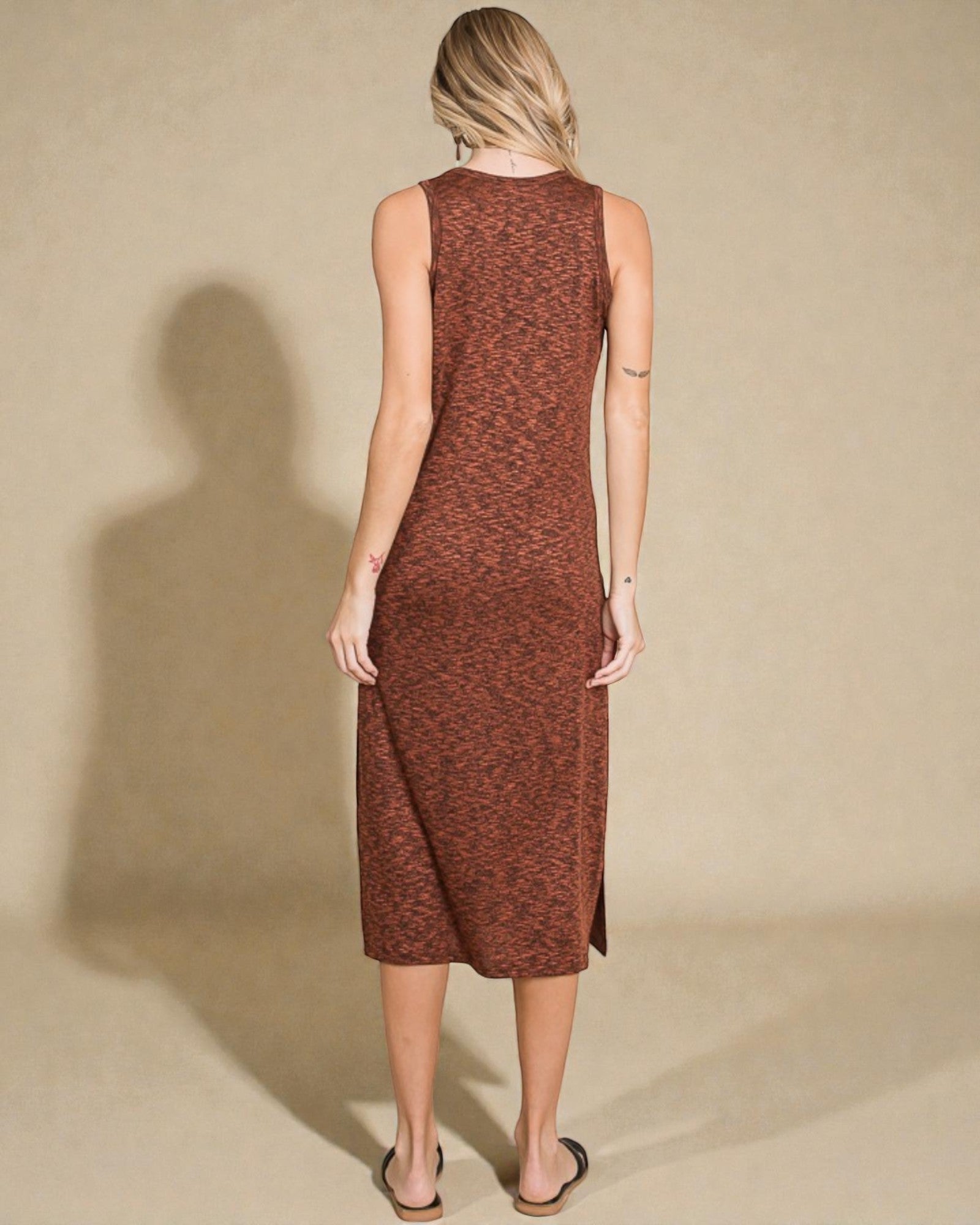 Woman wearing a brown sleeveless dress against a beige background